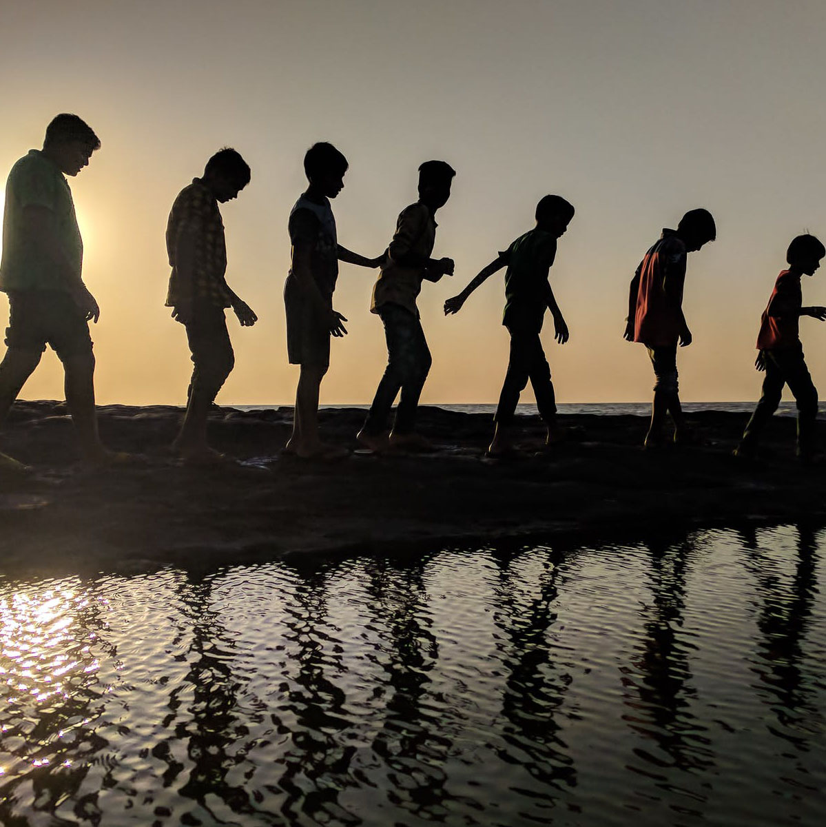 A montage of adolescent to child walking across sand dunes